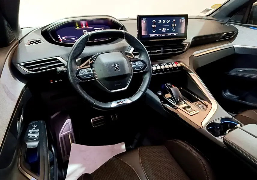 Vue intérieure avant du Peugeot 3008 GT 2023, volant cuir, écran tactile central et console moderne noire.