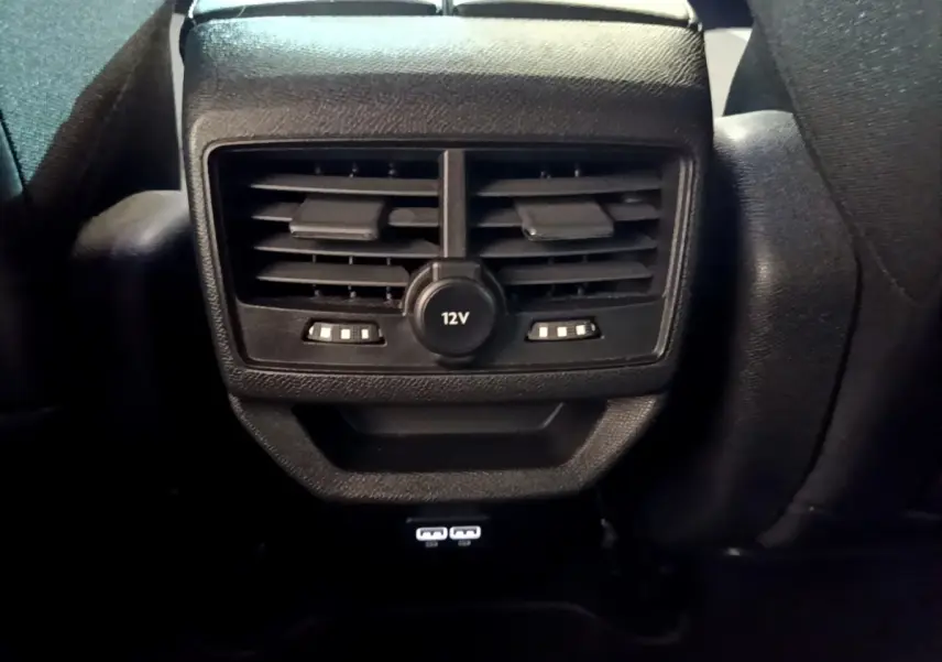 Détail de la console arrière noire du Peugeot 3008 2023 avec prises 12V et USB visibles.