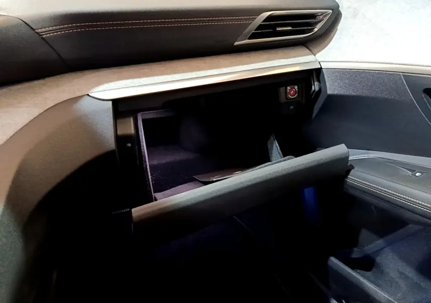 Intérieur Peugeot 3008 GT 2023, vue sur la boîte à gants ouverte côté passager avec surpiqûres orange visibles.