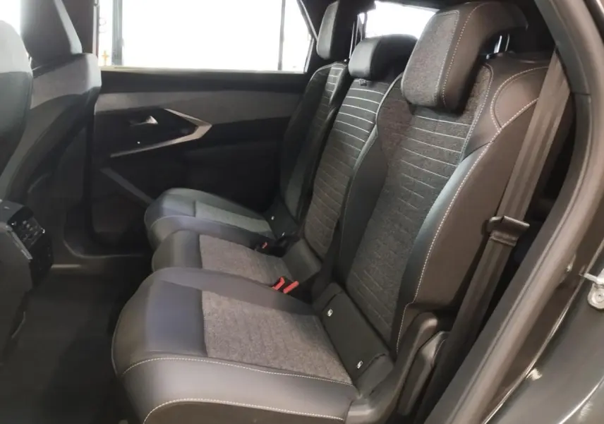 Vue latérale droite sur la banquette arrière gris titanium en tissu et cuir du Peugeot 5008 2025 Allure hybride.