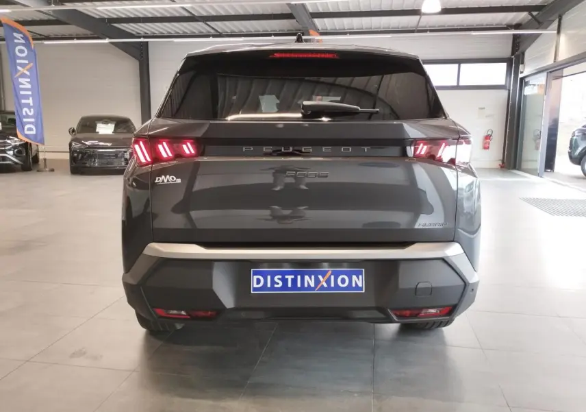 Vue arrière d’un Peugeot 5008 gris titanium hybride avec feux arrière LED 3 griffes et bandeau noir laqué.