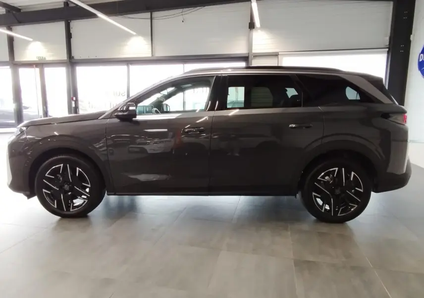 Profil côté gauche du Peugeot 5008 gris titanium 2025 avec jantes alliage 19'' diamantées noires brillantes.