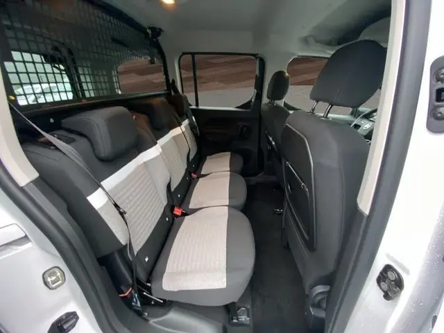 Vue intérieure côté droit sur la banquette arrière grise et beige du Citroën Berlingo blanc 2025 avec cloison métallique.