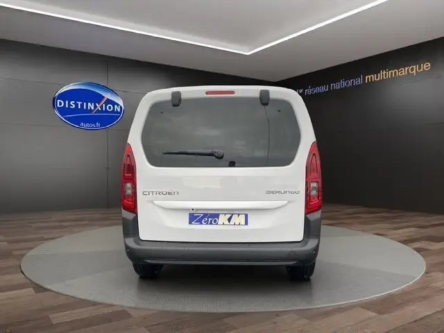 Vue arrière d'un Citroën Berlingo blanc 2025, avec hayon vitré et feux arrière verticaux rouges.