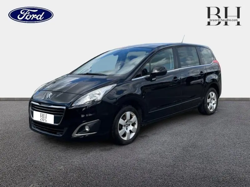 Vue 3/4 avant droit d'un Peugeot 5008 noir Perla Nera avec jantes alu et vitres arrière surteintées.