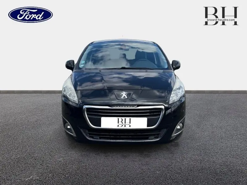 Vue avant d'un Peugeot 5008 noir Perla Nera, mettant en valeur sa calandre chromée et ses phares halogènes.