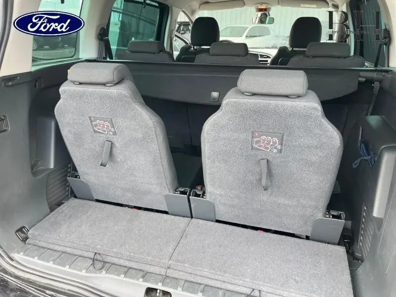 Vue arrière intérieure du Peugeot 5008 noir Perla Nera montrant les deux sièges supplémentaires rabattus en rang 3.