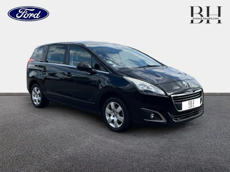 Peugeot 5008 noir Perla Nera vue 3/4 avant droit, avec vitres arrière surteintées et jantes alu.