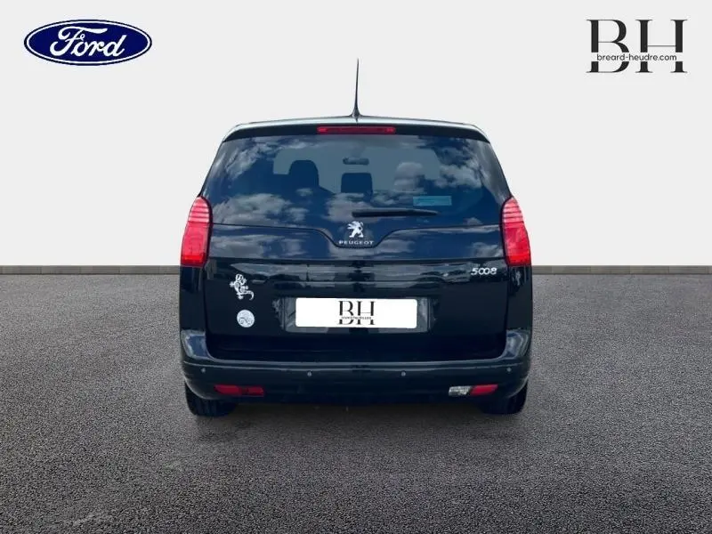 Vue arrière d'un Peugeot 5008 noir Perla Nera avec feux rouges verticaux et vitres arrière surteintées.
