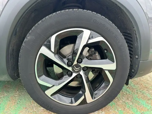 Gros plan sur la jante alliage bicolore noire et argent du Citroën C5 Aircross marron, côté roue avant droite.