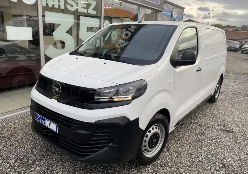Vue 3/4 avant droit d’un utilitaire Opel Vivaro blanc avec calandre noire et jantes tôles grises.