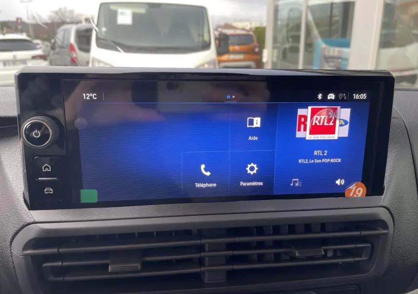 Écran tactile 10 pouces affichant la radio RTL2 dans l'habitacle d'un Opel Vivaro blanc, vue frontale rapprochée.