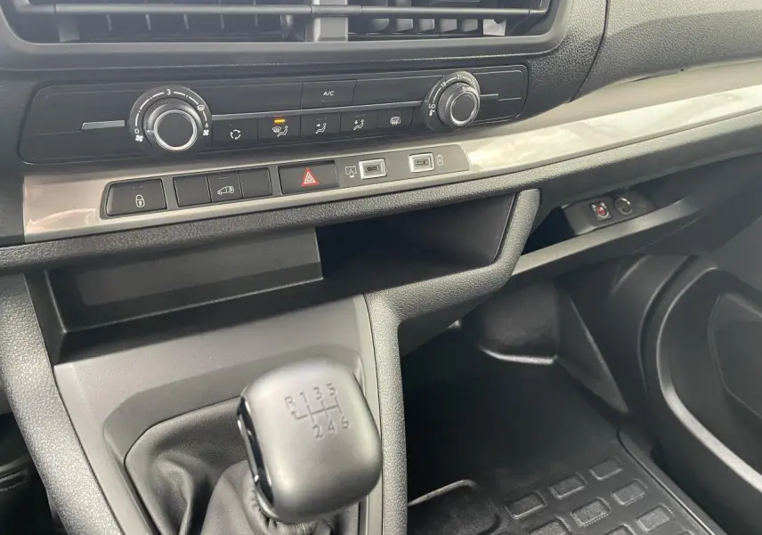 Gros plan sur la console centrale et levier de vitesses manuel du Opel Vivaro blanc 2024, intérieur noir.