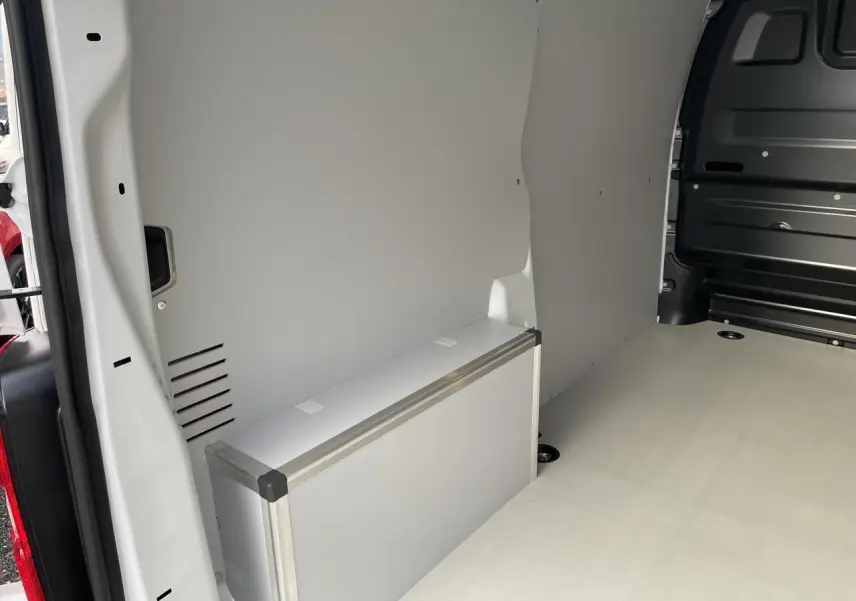 Intérieur arrière du fourgon blanc Opel Vivaro 2024, plancher bois clair et coffrage latéral en bois revêtu.