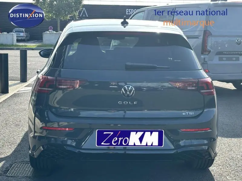 Vue arrière d'une Volkswagen Golf gris 2025 eTSI hybride avec logo R-Line et feux LED distinctifs.