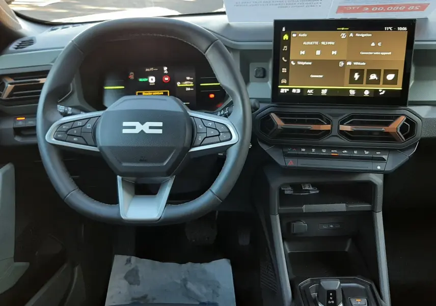 Vue intérieure du tableau de bord du Dacia Duster 2025 avec volant multifonction et écran tactile central.