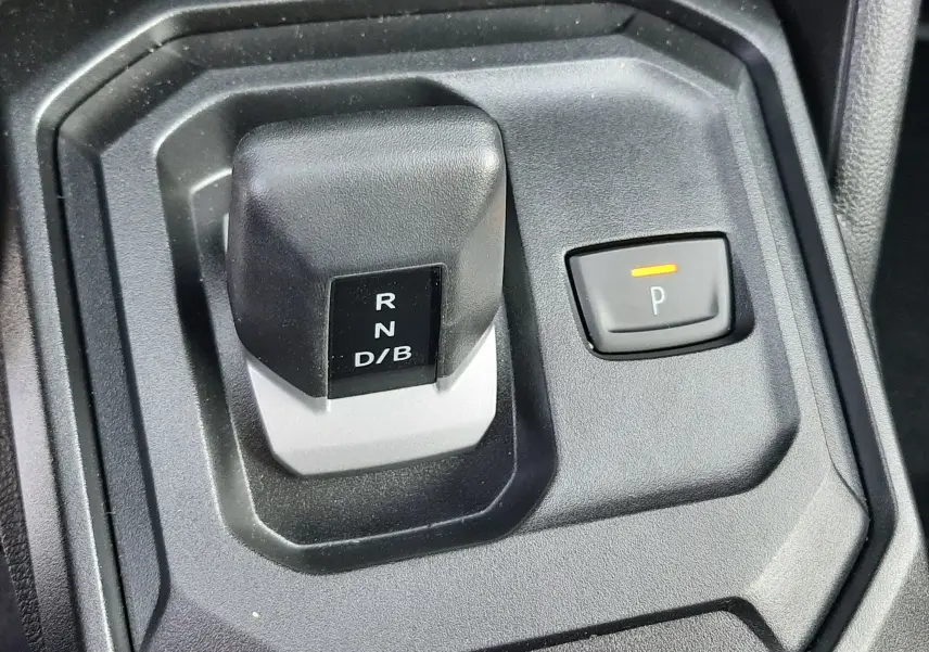 Gros plan sur le levier de vitesses automatique et bouton parking du Dacia Duster 1.6 Hybrid 140ch couleur Sandstone.