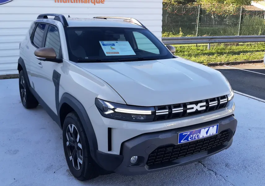 Dacia Duster 1.6 Hybrid 140ch Extreme couleur Sandstone en 3/4 avant droit avec calandre noire et jantes biton.