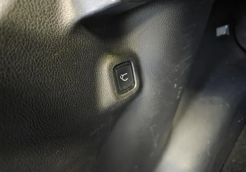 Bouton noir d'ouverture électrique du hayon sur panneau intérieur d'une Jeep Compass gris foncé