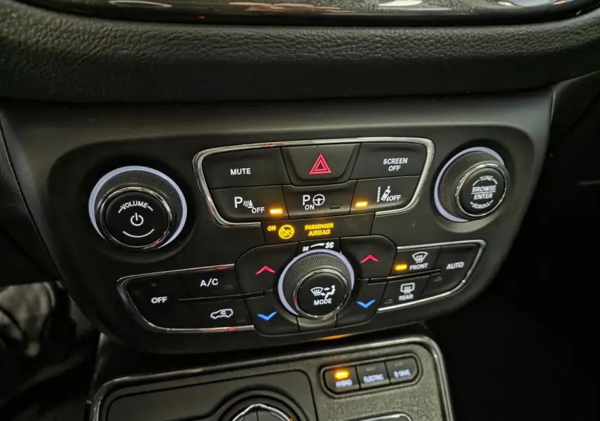 Tableau de bord du Jeep Compass 2020, détail des commandes de climatisation et aides à la conduite en noir.