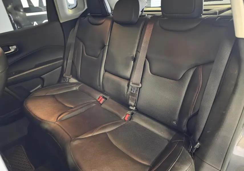 Banquette arrière en cuir noir du Jeep Compass 2020, vue latérale gauche avec ceintures de sécurité visibles.