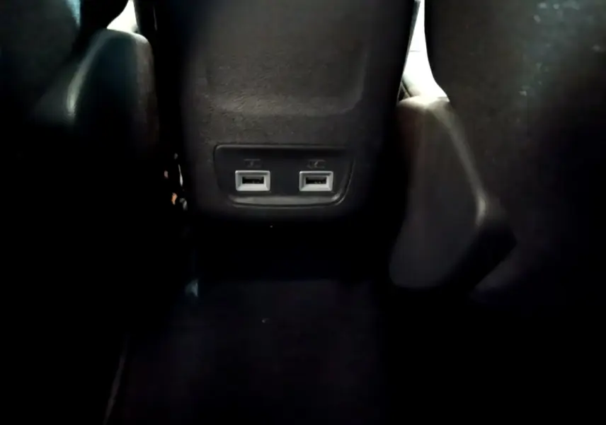 Prise USB double vue en gros plan à l'arrière des sièges noirs de la Peugeot 208 jaune 2023.