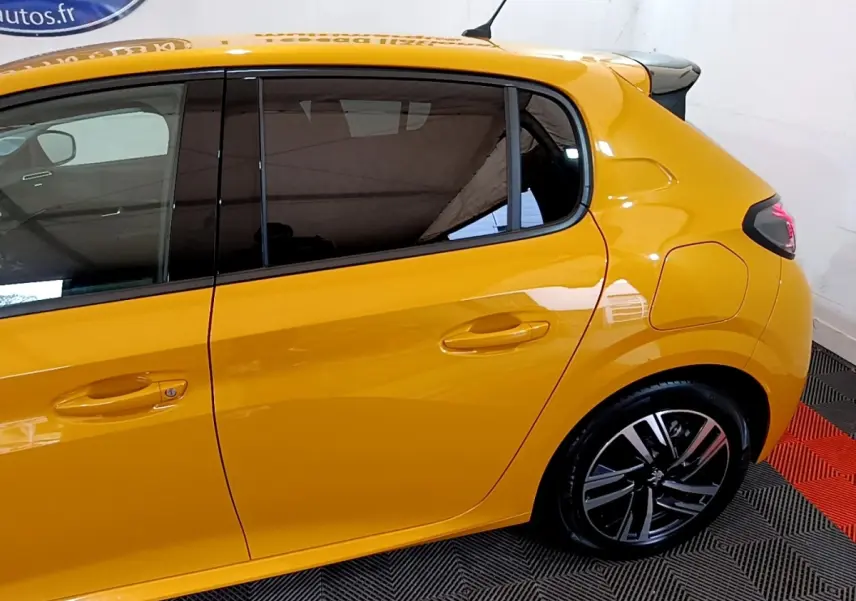 Vue latérale droite d'une Peugeot 208 jaune 2023 avec jantes alliage et vitres teintées.