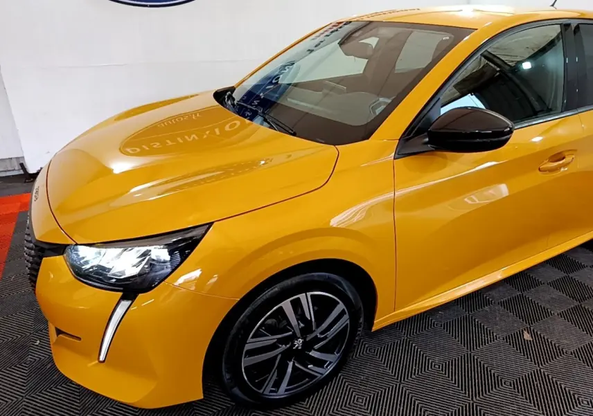 Vue 3/4 avant droit d'une Peugeot 208 jaune vif avec feux LED et jantes alliage noires.