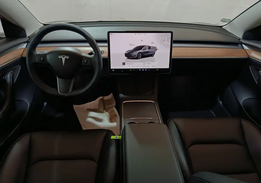 Intérieur Tesla Model 3 2022 vue avant, tableau de bord avec écran tactile central 15 pouces et volant noir.