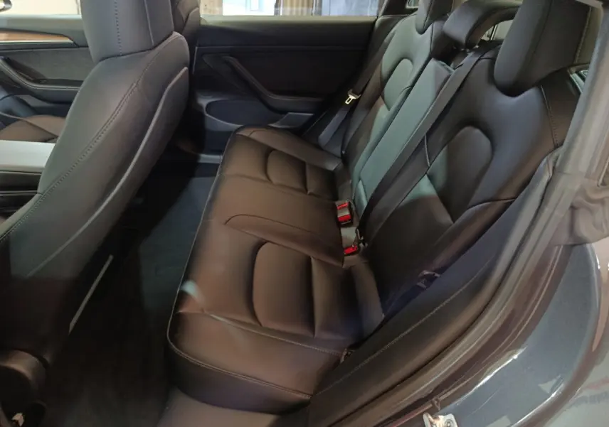 Vue intérieure côté droit sur la banquette arrière en cuir noir du Tesla Model 3 Grande Autonomie gris foncé 2022.