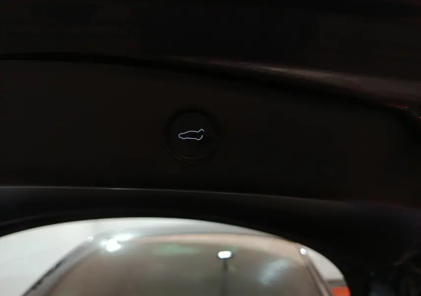 Bouton d'ouverture du coffre intérieur noir sur Tesla Model 3 Grande Autonomie gris foncé, vue depuis l'arrière ouvert.