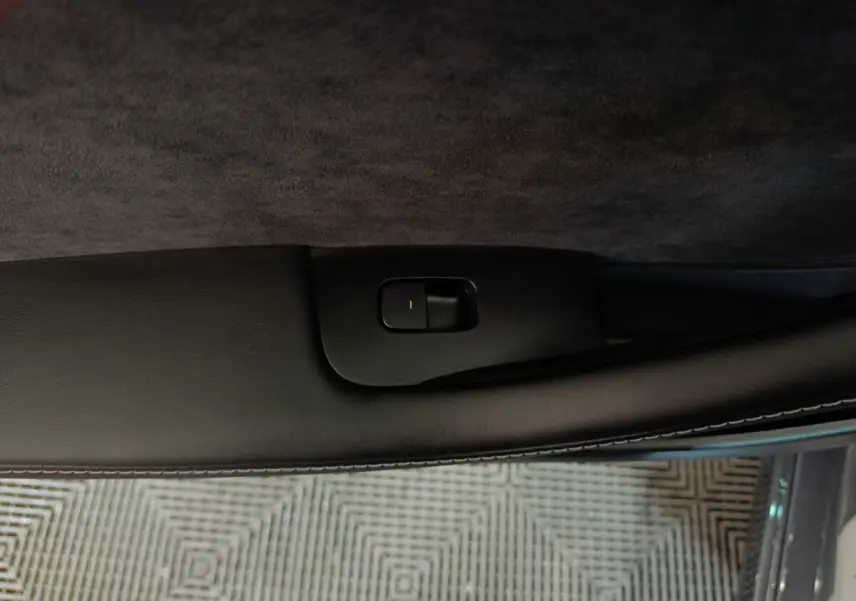 Gros plan sur la commande de verrouillage de porte côté conducteur d’une Tesla Model 3 gris foncé.