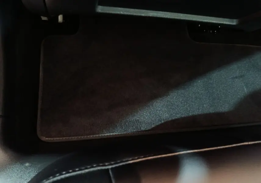 Vue intérieure du tapis de sol avant noir dans une Tesla Model 3 Grande Autonomie gris foncé de 2022.