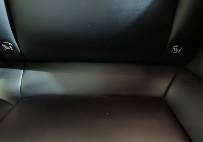 Gros plan sur la banquette arrière en cuir noir de la Tesla Model 3 Grande Autonomie 2022, avec indications Isofix visibles.