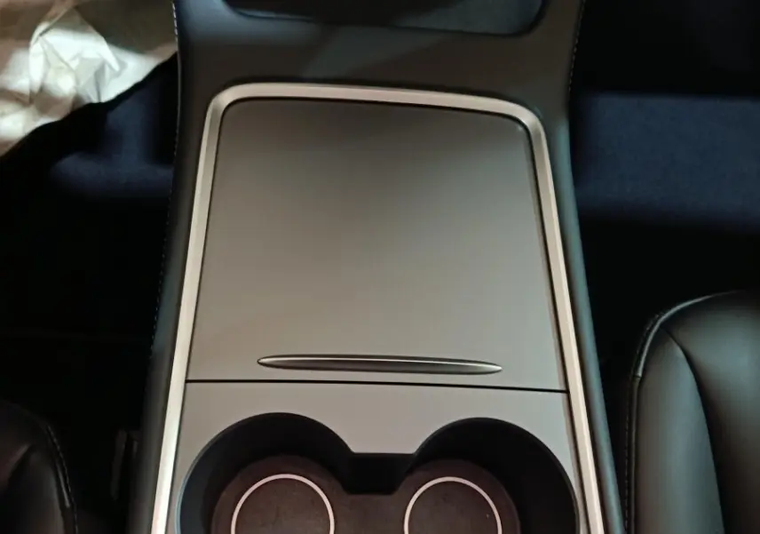 Vue plongeante sur la console centrale grise avec porte-gobelets du Tesla Model 3 Grande Autonomie 2022.
