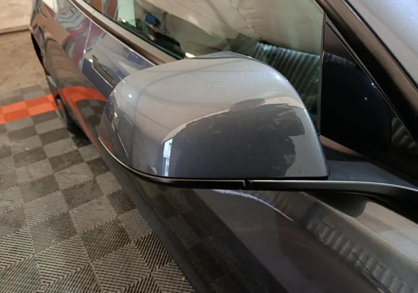 Rétroviseur côté conducteur gris foncé de la Tesla Model 3 Grande Autonomie 2022, vue rapprochée en angle avant gauche.