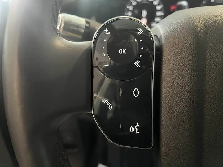 Gros plan sur les commandes au volant noir du Range Rover Evoque II 2020, avec boutons de navigation et téléphone.