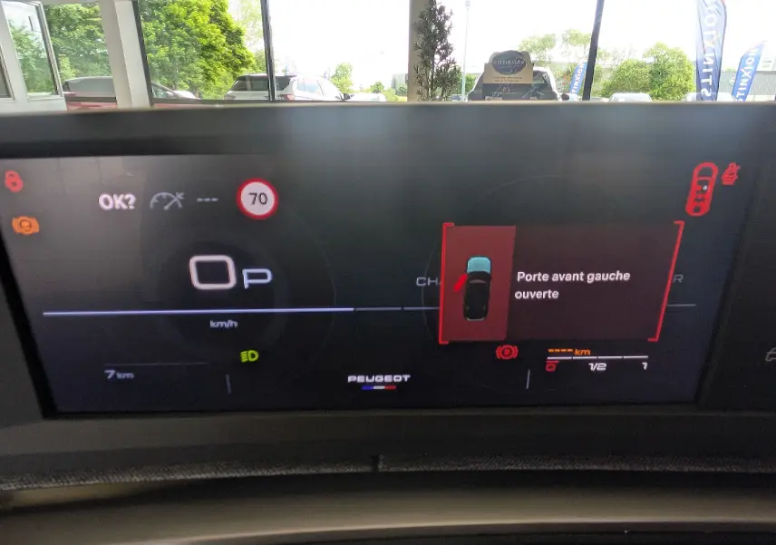 Affichage numérique du tableau de bord du Peugeot 5008 blanc, indiquant porte avant gauche ouverte et vitesse à 0 km/h.