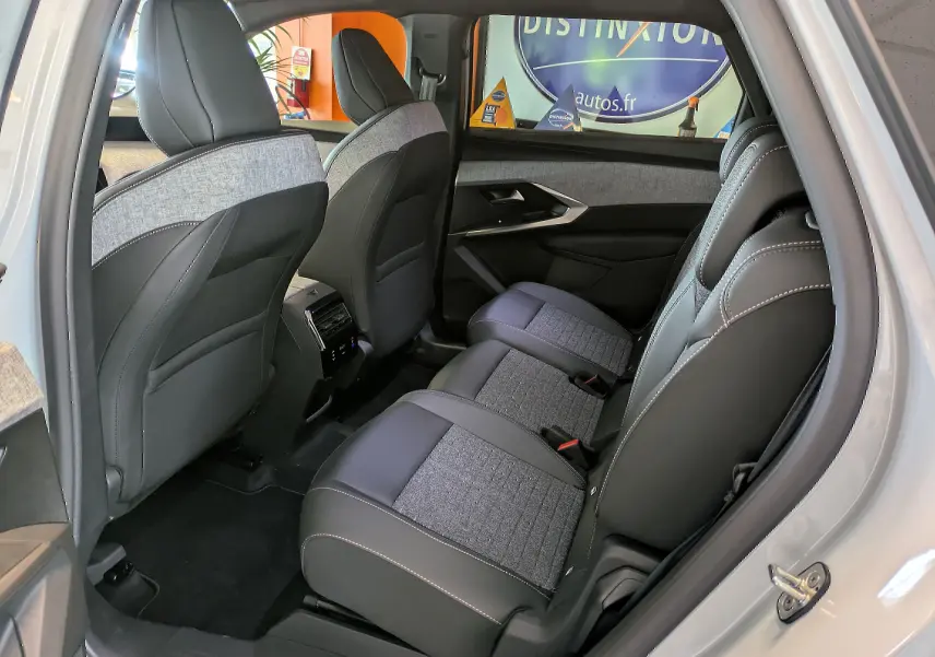 Vue intérieure côté droit des sièges arrière du Peugeot 5008 blanc Okenite, avec sellerie mixte tissu et cuir gris.