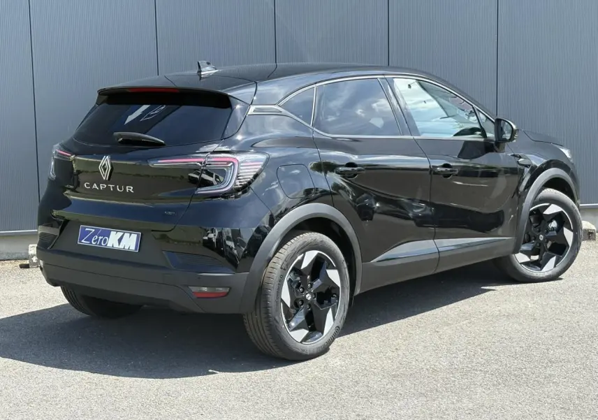 Vue 3/4 arrière droite d'un Renault Captur noir étoile avec jantes aluminium 18 pouces et vitres surteintées.