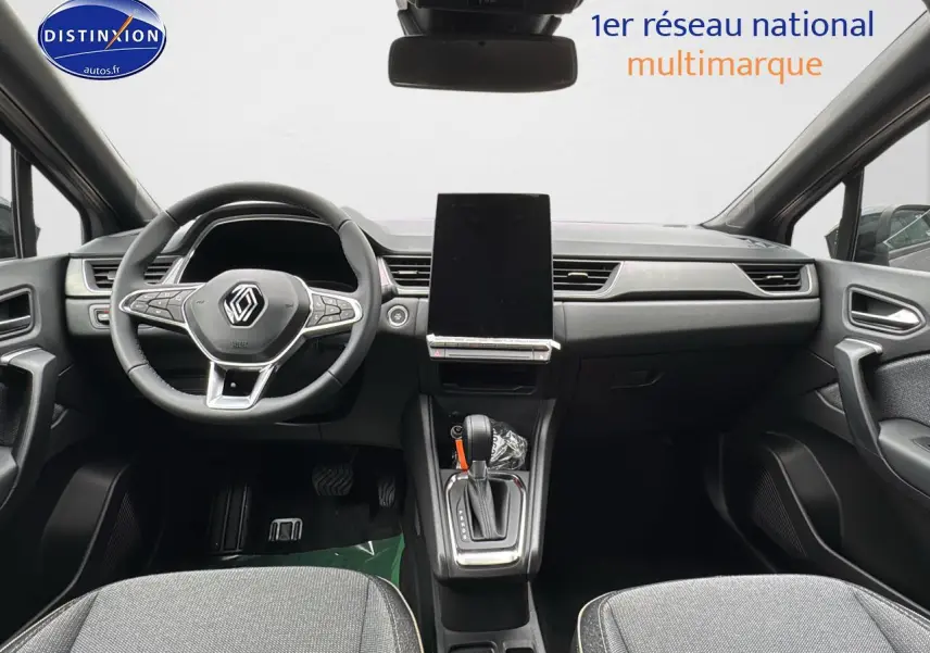 Intérieur avant du Renault Captur gris cassiopée, vue centrée sur le tableau de bord et le volant multifonction.