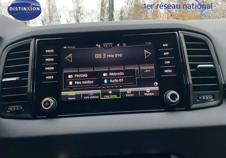 Écran central tactile du tableau de bord du Skoda Karoq gris argent, affichant les options radio et médias Bluetooth.