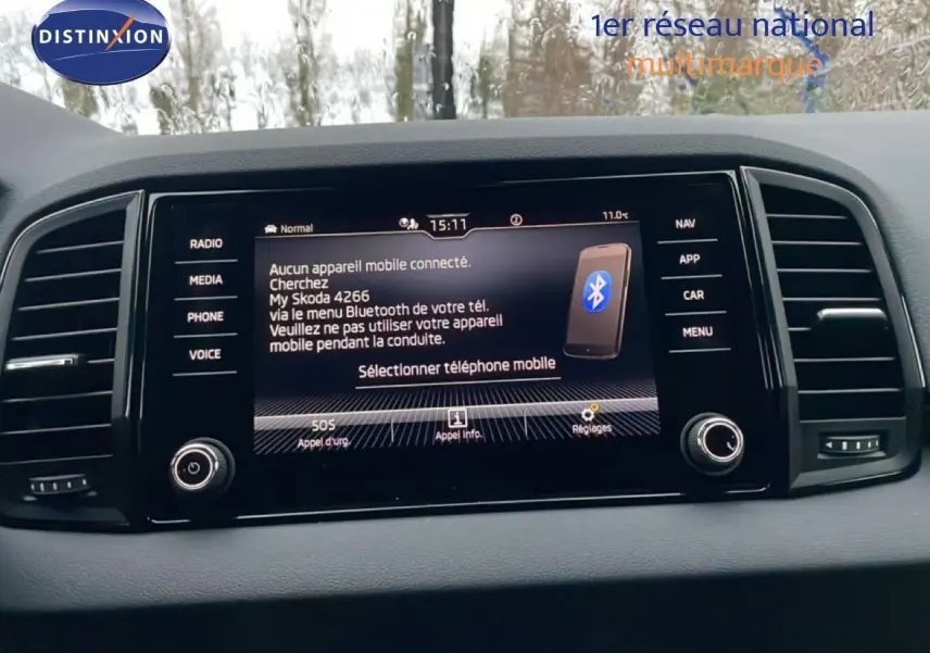 Vue rapprochée de l’écran central tactile du Skoda Karoq 2025 affichant la connexion Bluetooth, entouré de commandes noires.