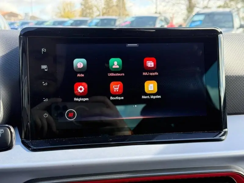 Écran tactile central du tableau de bord du SEAT Arona 2025 affichant les menus Aide, Utilisateurs, MAJ applis, Réglages, Boutique et Mentions légales.