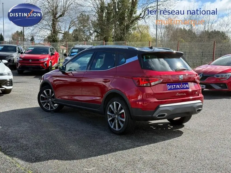 SEAT Arona 2025 rouge Désir avec toit noir Minuit, vue 3/4 arrière droit, jantes alliage et double sortie d’échappement.
