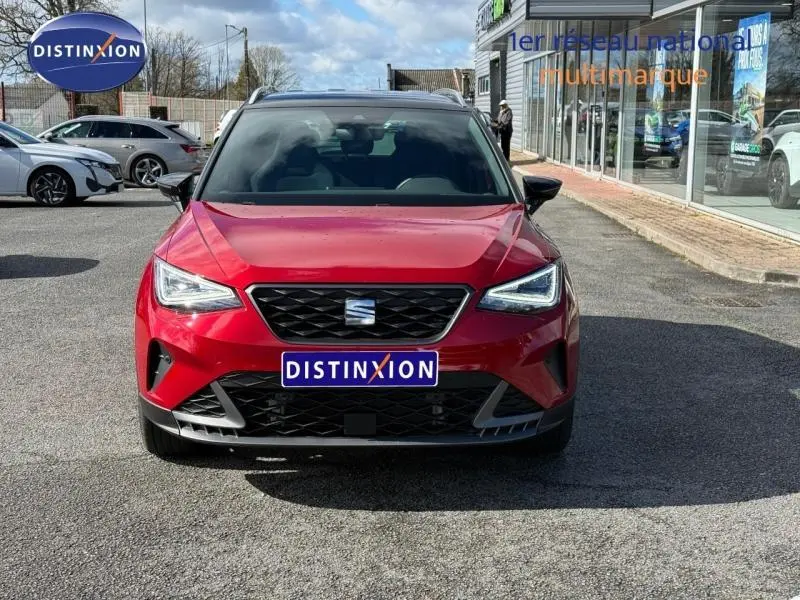 Vue de face d'un SEAT Arona 2025 rouge Désir avec toit noir, mettant en valeur sa calandre et ses phares LED anguleux.
