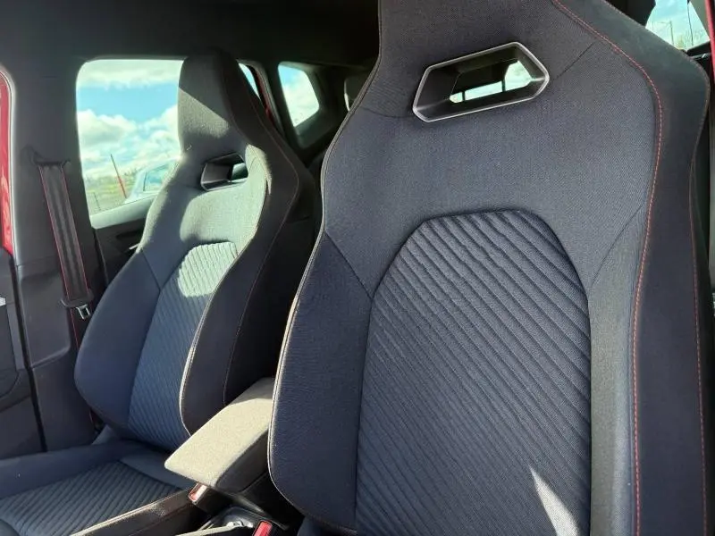 Gros plan sur les sièges avant sport noirs avec surpiqûres rouges du SEAT Arona 2025, intérieur côté conducteur et passager.