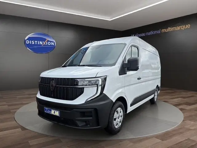 Vue 3/4 avant d’un Renault Master blanc avec calandre noire et pare-chocs contrasté dans un showroom.