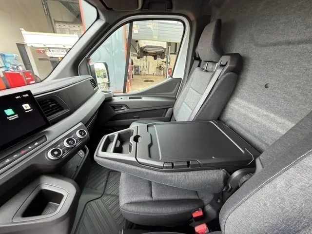 Vue intérieure côté passager du Renault Master blanc 2025, avec tablette rabattable et tableau de bord tactile.