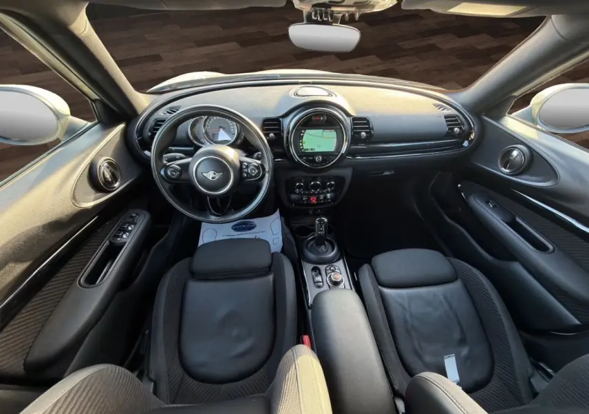Vue intérieure avant de la MINI Clubman F54 Cooper Exquisite 2019, tableau de bord noir avec écran tactile et volant cuir.